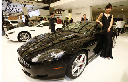 A model displays an Aston Martin sports car at the Shanghai auto expo in Shanghai, east China, on April 20, 2009. 