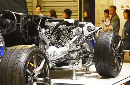 Visitors look at an auto dissection of a sports car at the showroom of the Dongfeng Nissan Passenger Vehicle company at the Shanghai auto expo in Shanghai, east China, on April 20, 2009.