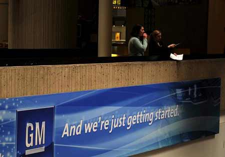 Two workers talk at the headquarters of General Motors Corp.(GM) in Detroit, the United States, on April 14, 2009. GM announced on Monday that it would cut 1,600 white-collar workers this week as a step to cut costs that could help the automaker qualify for more government aid. 
