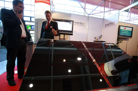An exhibitor (R) introduces solar power technique to a visitor during the 'Hannover Messe' industrial trade fair in Hanover, Germany, on April 20, 2009. 