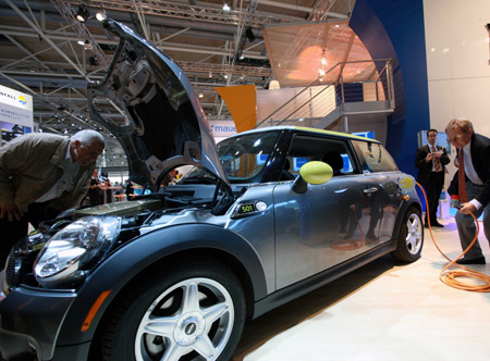 Visitors look at an electric car during the 'Hannover Messe' industrial trade fair in Hanover, Germany, on April 20, 2009. 