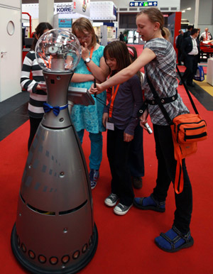 Visitors look at a shopping-guide robot during the 'Hannover Messe' industrial trade fair in Hanover, Germany, on April 20, 2009. 