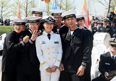 Members of South Korean navy's military band pose with an officer of Chinese People's Liberation Army Navy after a performance in Qingdao, east China's Shandong Province, on April 21, 2009.