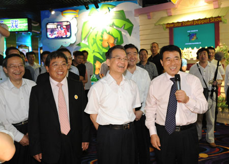Chinese Premier Wen Jiabao (2nd R, front), also a member of the Standing Committee of the Political Bureau of the Communist Party of China (CPC) Central Committee, laughs as he watches an animation in Shenzhen Huaqiang Holdings Ltd., south China's Guangdong Province, on April 19, 2009.