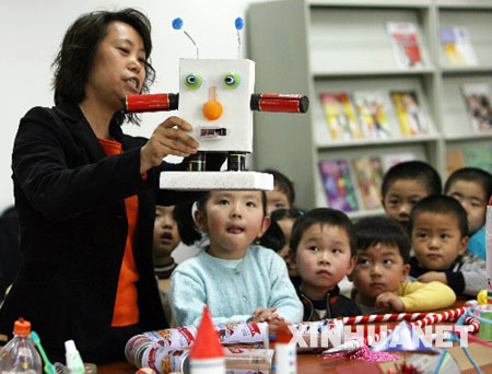 A teacher tells children how a robot has been made from waste materials in the Hongqiao Kindergarten of Suzhou, Jiangsu Province on April 20, 2009. The Earth Day, celebrated on every April 22, is a day designed to inspire people's awareness and appreciation for the Earth's environment.