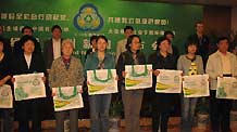 Representatives of 30 Beijing residents' committees receive free environment-friendly bags at the 'Green World' press conference on April 22.