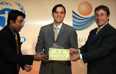Achim Steiner(R1), under-secretary general of the United Nations and executive director of the UN environment programme (UNEP), awards tropical forest and climate campaigner Kevin Conrad with Policy Leadership Prize during the awarding ceremony of Champion of the Earth in Paris, on April 22, 2009.
