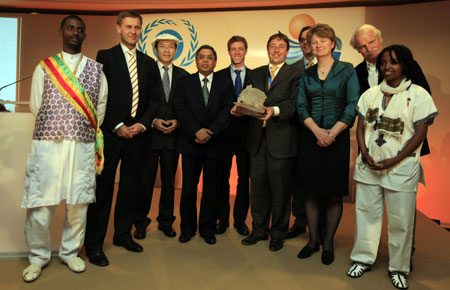 Achim Steiner(R5), under-secretary general of the United Nations and executive director of the UN environment programme (UNEP), and Chinese artist Yuan Xikun(L3), designer of the 2009 trophy, pose for family photos with prize bearers during the awarding ceremony of Champion of the Earth in Paris, on April 22, 2009. 