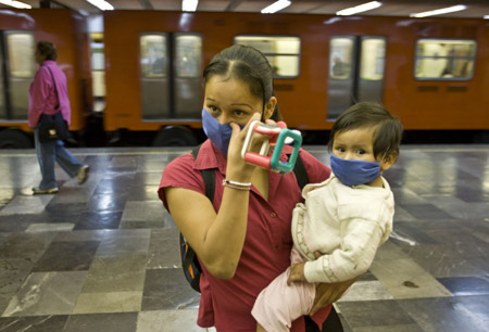 A woman and her child wear masks to prevent from being infected by the swine flu virus in the Mexico City, capital of Mexico, on April 25, 2009.