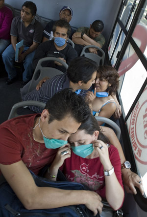 People on a bus wear masks to prevent from being infected by the swine flu virus in the Mexico City, capital of Mexico, on April 25, 2009.