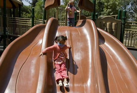 Girls wearing masks play outside to prevent from being infected by the swine flu virus in the Mexico City, capital of Mexico, on April 25, 2009. 