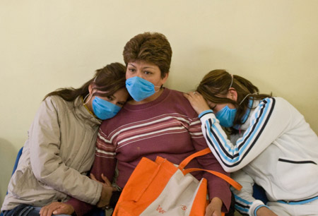 Woman wearing masks wait inside a health center in Mexico City, capital of Mexico, on April 24, 2009.