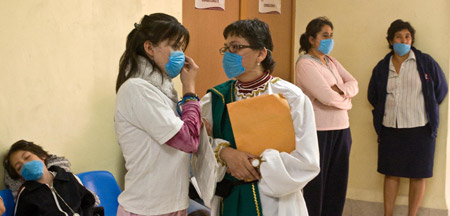 People wearing masks wait at a health center in Mexico City, capital of Mexico, on April 24, 2009. 