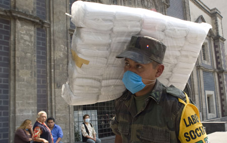 A Mexican soldier carries a pack of masks which will be distributed to pedestrians in Mexico City, capital of Mexico, April 25, 2009. Mexican government has handed out 6 million masks for free to citizens of Mexico City since April 23. The World Health Organization (WHO) on Saturday declared the swine flu outbreak in Mexico and the United States a 'public health emergency of international concern' and urged countries to be alert.