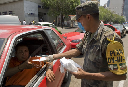 A Mexican soldier hands out masks in Mexico City, capital of Mexico, on April 25, 2009.