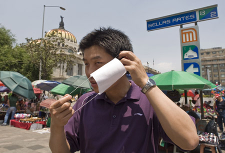 A Chinese tourist puts on a mask in Mexico City, capital of Mexico, on April 25, 2009. 