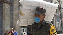 A Mexican soldier carries a pack of masks which will be distributed to pedestrians in Mexico City, capital of Mexico, April 25, 2009.