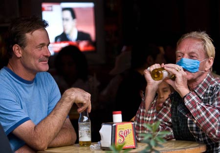 Tourists wearing masks drink beer in downtown Mexico City, capital of Mexico, on April 25, 2009. Of the 81 deaths suspected of being caused by swine influenza in Mexico, 20 are confirmed. More than 1,300 people in Mexico were suspected to be infected with the flu.