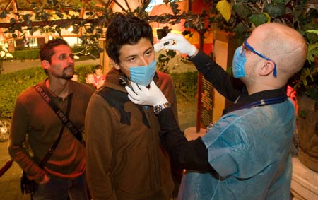 A medical staff measures body temperature of a man who prepares to enter the downtown areas of Mexico City, capital of Mexico, on April 25, 2009. 