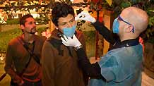 A medical staff measures body temperature of a man who prepares to enter the downtown areas of Mexico City, capital of Mexico, on April 25, 2009.