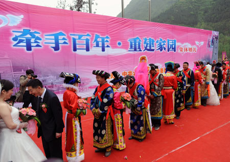 Twenty new couples attend a group wedding at the Jina Qiang Ethnic Minority Village of Beichuan County, southwest China&apos;s Sichuan Province, on April 26, 2009.