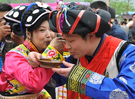 Bride Zhang Li and bridegroom Tang Jiyao drink at the Jina Qiang Ethnic Minority Village of Beichuan County, southwest China's Sichuan Province, on April 26, 2009. Twenty new couples held group wedding on Sunday.