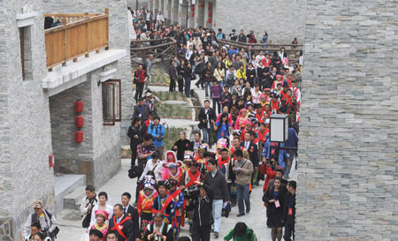 Twenty new couples parade as they hold group wedding at the Jina Qiang Ethnic Minority Village of Beichuan County, southwest China's Sichuan Province, on April 26, 2009. Twenty new couples held group wedding on Sunday.