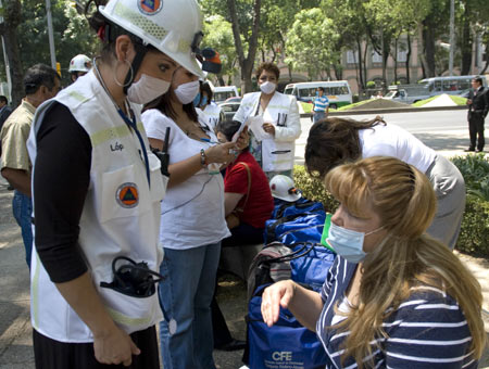 A medical worker (L) offers help to a woman after an earthquake in Mexico City, captial of Mexico, on April 27, 2009. 