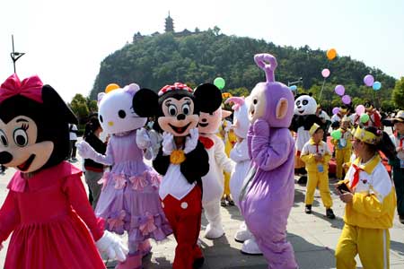 Different cartoon stars play with children in a scenic spot of Nantong Horticulture Expo Park in Nantong, a city of east China's Jiangsu Province, on April 27, 2009.