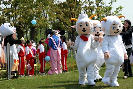 Cartoon stars Happy Sheep play with children in a scenic spot of Nantong Horticulture Expo Park in Nantong, a city of east China's Jiangsu Province, on April 27, 2009.