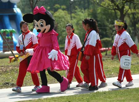 Cartoon star Mickey Mouse plays with children in a scenic spot of Nantong Horticulture Expo Park in Nantong, a city of east China's Jiangsu Province, on April 27, 2009.