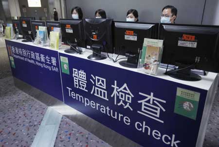 Staff members check the temperature of passengers with the help of machines at Hong Kong International Airport in Hong Kong, south China, on April 27, 2009. Hong Kong Special Administrative Region has taken measures to contain the possible spread of swine flu.