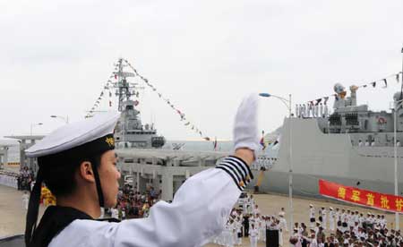 A sailor of Chinese warship DDG-169 Wuhan waves to the people during a welcome ceremony held at a port in Sanya, south China's Hainan Province, on April 28, 2009. 