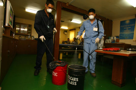 Chinese quarantine staff sanitize and disinfect a foreign sea vessel on arrival at the Ningbo seaport in east China's Zhejiang Province on April 28, 2009. 
