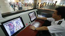 A Chinese quarantine staff checks the body temperature for passengers on arrival at the Gongbei Customs near Zhuhai city in south China's Guangdong Province on April 28, 2009. Chinese government announced on Tuesday that no human cases of swine flu have been detected in China and that all precautions against the disease's possible spread have been taken.