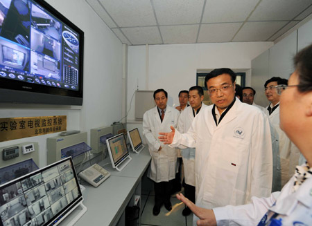 Chinese Vice Premier Li Keqiang (C) visits a laboratory of the Chinese Center for Disease Control and Prevention in Beijing, capital of China, on April 29, 2009. Li visited the Chinese Center for Disease Control and Prevention and Capital International Airport in Beijing to inspect the operations of swine flu prevention on April 29. 