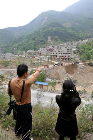 Picture taken on April 26, 2009 shows two journalists look at a newly-built township in Beichuan Qiang Autonomous County, southwest China's Sichuan Province. Life has resumed normal here after last May's devastating earthquake. People in the region are struggling for a better future.