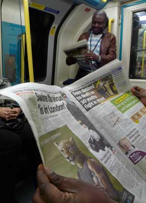 A passenger reads news about swine flu on an underground train in London, the United Kingdom, on April 28, 2009. 