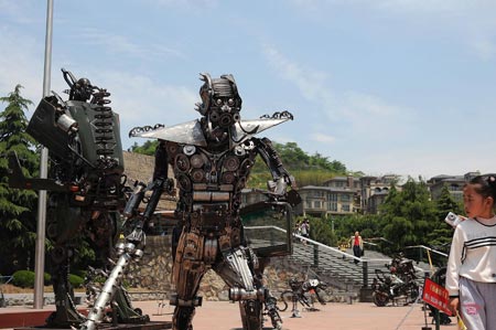 Visitors step around a giant cartoon figure of the Transformer, exhibited at the cartoon and animation industry fair, at the World Leisure Expo Garden, in Hangzhou, east China's Zhejiang Province, on April 29, 2009. A total of 322 exhibitors at home and abroad take part in the cartoon and animation industry fair of the 5th China International Cartoon and Animation Festival.