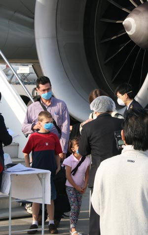 Passengers of AeroMexico flight AM098 receive quarantine checks up on their arrival at the Shanghai Pudong International Airport in east China's Shanghai municipality, April 30, 2009. It's the first flight from Mexico to China since the spread of swine flu, and serious quarantine measures were taken at the airport. (Xinhua/Pei Xin)