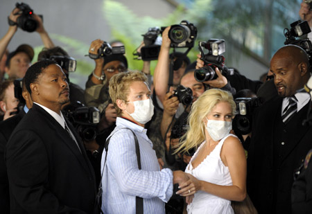 Heidi Montag (2nd R) and Spencer Pratt (2nd L) arrive at the international airport in Los Angeles, the United States, on April 29, 2009, after returning from their honeymoon in Mexico. Affected by swine flu, the number of the passengers decreased on over 40 flights at the Los Angeles International Airport, a major aviation terminal between the United States and Mexico. 