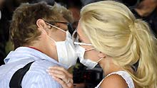 Heidi Montag (R) and Spencer Pratt (L) kiss at the international airport in Los Angeles, the United States, on April 29, 2009, after returning from their honeymoon in Mexico. Affected by swine flu, the number of the passengers decreased on over 40 flights at the Los Angeles International Airport, a major aviation terminal between the United States and Mexico.