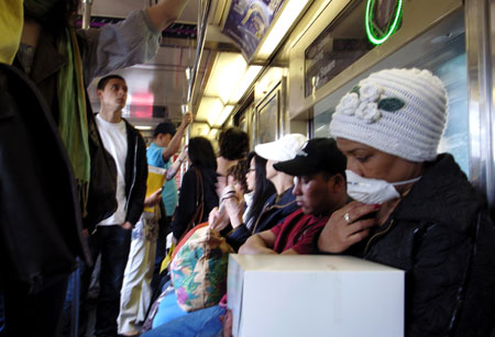 A woman wears a mask while taking subway train in New York, the United States, on April 29, 2009.