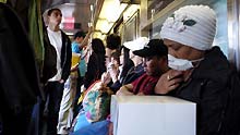 A woman wears a mask while taking subway train in New York, the United States, on April 29, 2009.