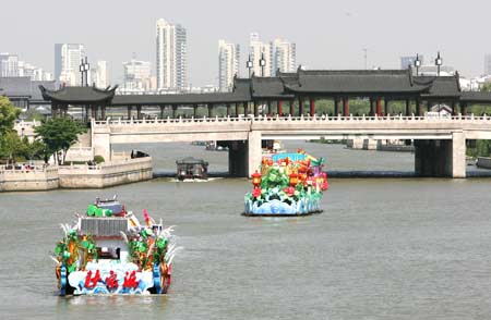 Some flowery boats cruise on the city-embracing river in Suzhou, a tourist city of east China's Jiangsu Province, on April 29, 2009. 