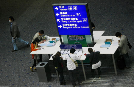 Visitors fill in health information cards at Hong Kong International Airport in Hong Kong, south China, May 1, 2009. 