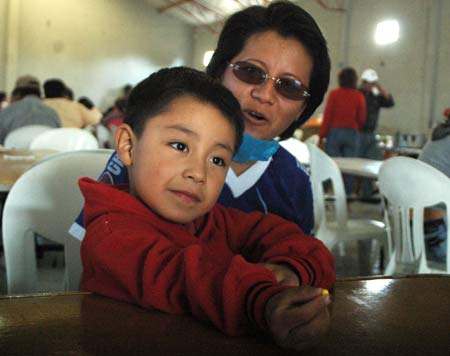 Four-year-old Edgar Hernandez (L) who has recovered from the A/H1N1 flu influenza recently, and his mother rest in a free dining room at his hometown in Veracruz state in Mexico on May 2, 2009. Hernandez is the first patient who was infected by the A/H1N1 flu influenza in Mexico.