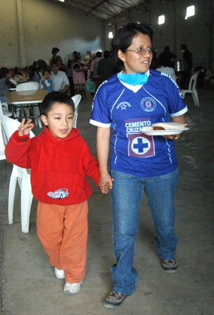 Four-year-old Edgar Hernandez (L), who has recovered from the A/H1N1 flu influenza recently, walks outside a free dining room with his mother at his hometown in Veracruz state in Mexico on May 2, 2009. Hernandez is the first patient who was infected by the A/H1N1 flu influenza in Mexico.