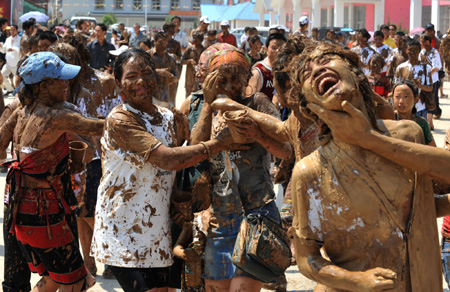 Tourists and the local Va ethnic people cover others with clay during a carnival at the Va Ethnic Autonomous Prefecture of Cangyuan, southwest China's Yunnan Province, May 2, 2009. During the 4-day festival, people daubing each other with the clay, made of natural material, to express wishes of health and happiness. (Xinhua/Chen Haining) 