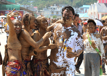 Tourists and the local Va ethnic people cover others with clay during a carnival at the Va Ethnic Autonomous Prefecture of Cangyuan, southwest China's Yunnan Province, May 2, 2009. During the 4-day festival, people daubing each other with the clay made of natural material, to express wishes of health and happiness. (Xinhua/Chen Haining) 